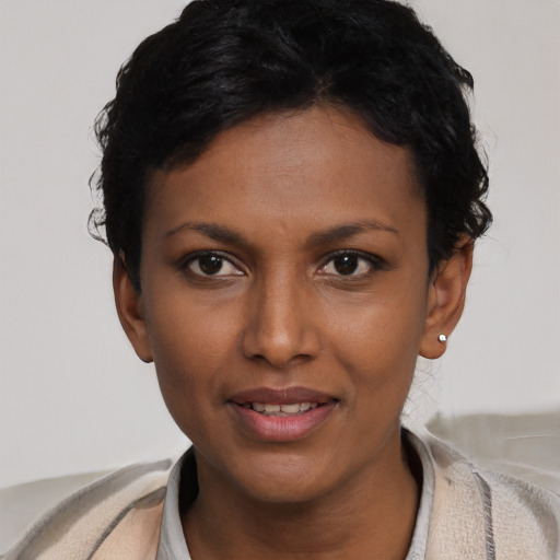 Joyful black young-adult female with short  black hair and brown eyes