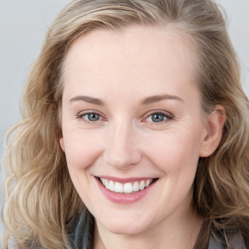 Joyful white young-adult female with long  brown hair and blue eyes