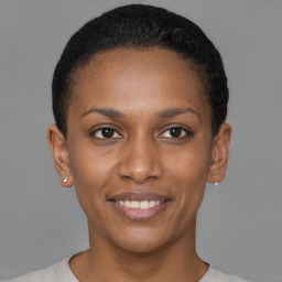 Joyful black young-adult female with short  brown hair and brown eyes