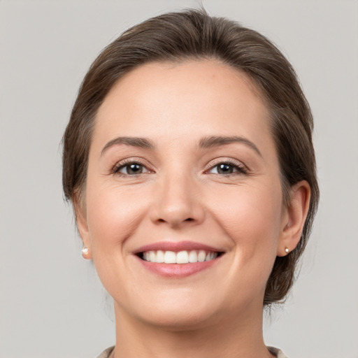 Joyful white young-adult female with medium  brown hair and grey eyes