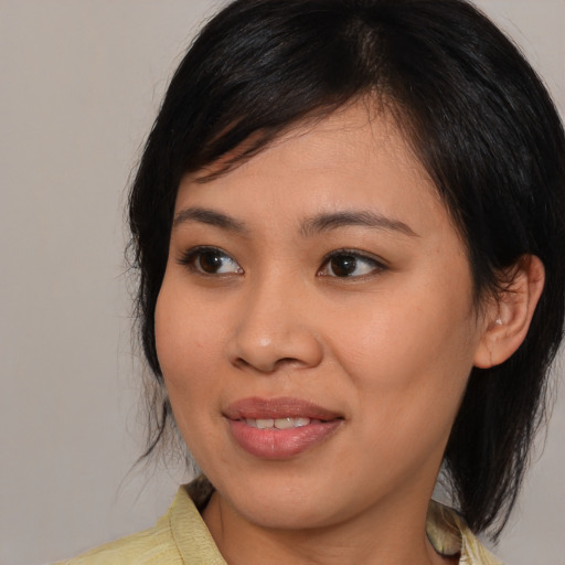 Joyful asian young-adult female with medium  black hair and brown eyes