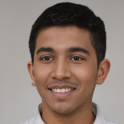 Joyful latino young-adult male with short  black hair and brown eyes