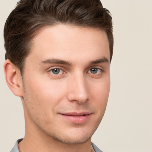 Joyful white young-adult male with short  brown hair and grey eyes