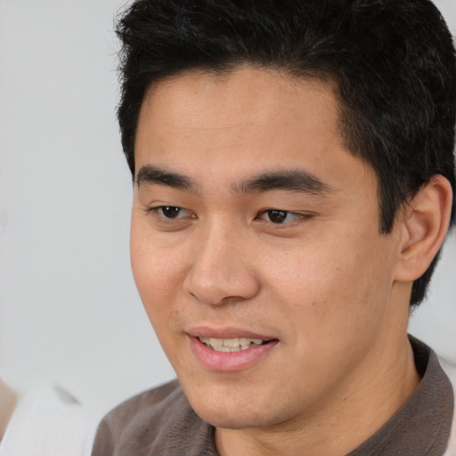 Joyful asian young-adult male with short  brown hair and brown eyes