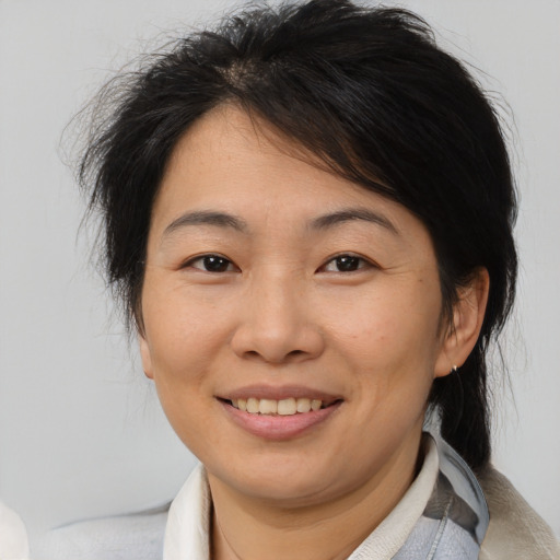 Joyful asian adult female with medium  brown hair and brown eyes