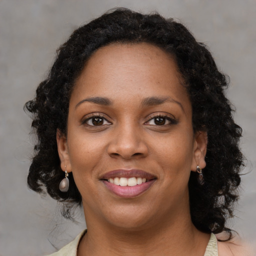 Joyful black young-adult female with medium  brown hair and brown eyes