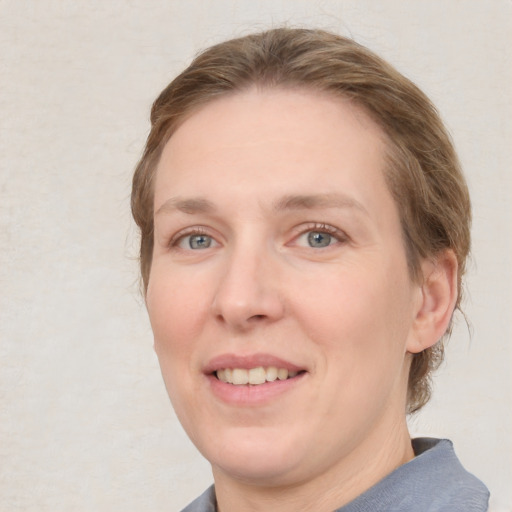 Joyful white adult female with medium  brown hair and blue eyes