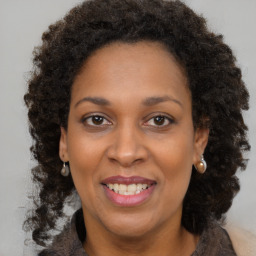 Joyful black adult female with medium  brown hair and brown eyes