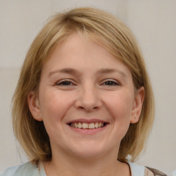 Joyful white young-adult female with medium  brown hair and blue eyes