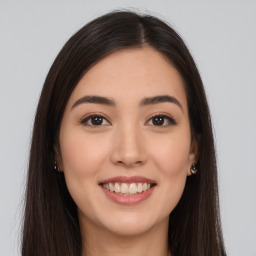 Joyful white young-adult female with long  brown hair and brown eyes