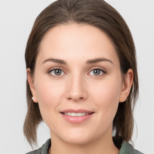 Joyful white young-adult female with medium  brown hair and grey eyes