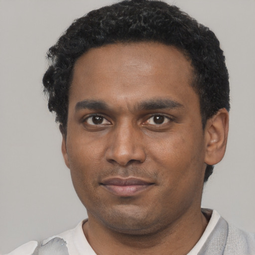Joyful black young-adult male with short  black hair and brown eyes