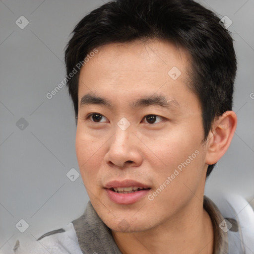 Joyful asian young-adult male with short  brown hair and brown eyes