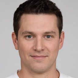 Joyful white young-adult male with short  brown hair and grey eyes