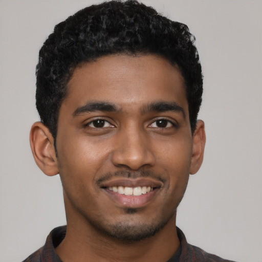 Joyful black young-adult male with short  black hair and brown eyes