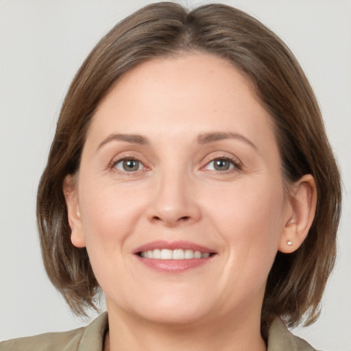 Joyful white adult female with medium  brown hair and grey eyes