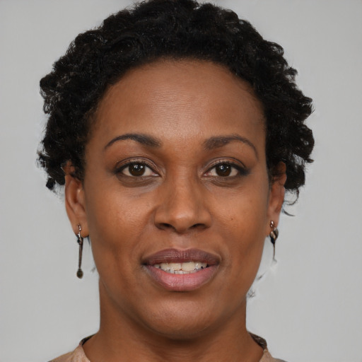 Joyful black adult female with short  brown hair and brown eyes