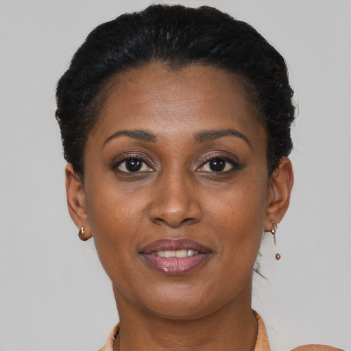 Joyful black young-adult female with short  brown hair and brown eyes