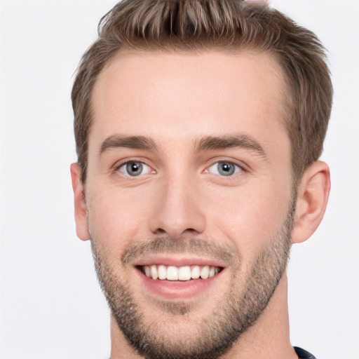 Joyful white young-adult male with short  brown hair and grey eyes