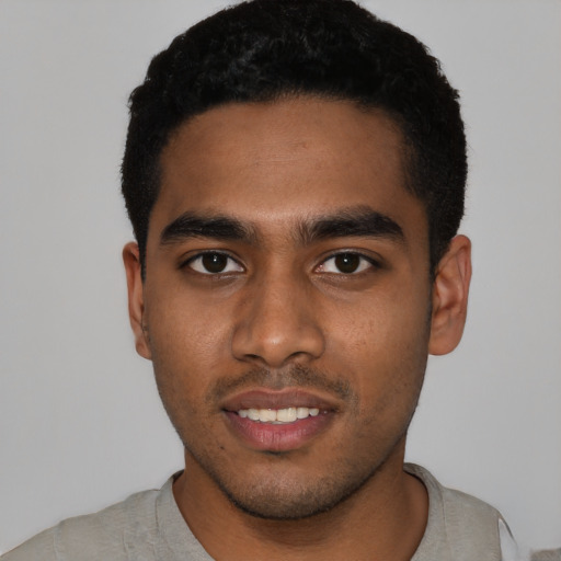 Joyful black young-adult male with short  black hair and brown eyes