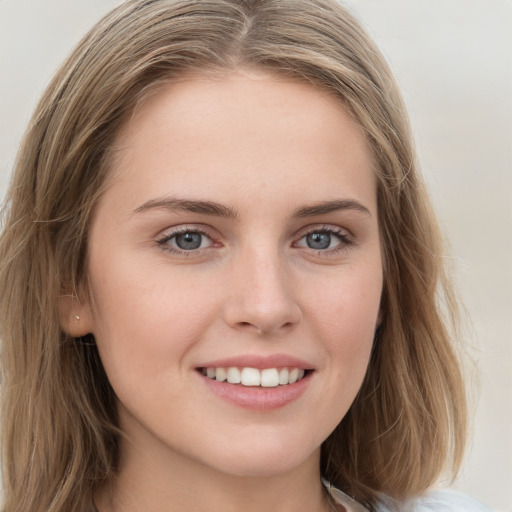 Joyful white young-adult female with long  brown hair and blue eyes