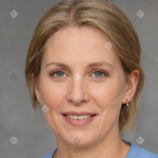 Joyful white adult female with medium  brown hair and blue eyes