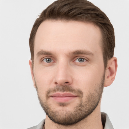 Joyful white young-adult male with short  brown hair and grey eyes