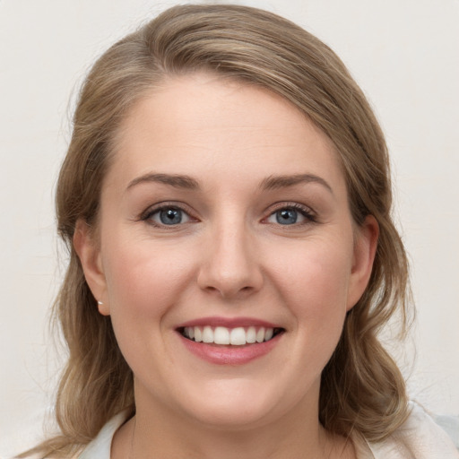 Joyful white young-adult female with medium  brown hair and blue eyes