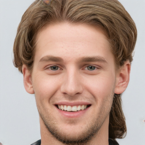 Joyful white young-adult male with short  brown hair and grey eyes