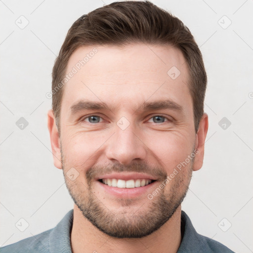 Joyful white young-adult male with short  brown hair and grey eyes