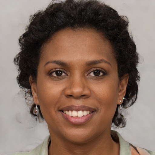 Joyful black young-adult female with medium  brown hair and brown eyes