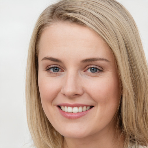 Joyful white young-adult female with long  brown hair and blue eyes