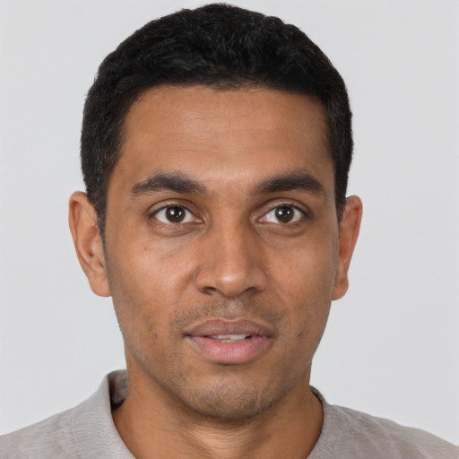 Joyful black young-adult male with short  black hair and brown eyes
