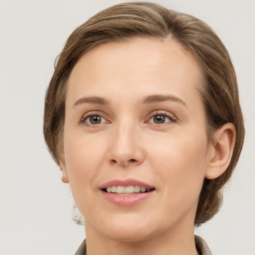 Joyful white young-adult female with medium  brown hair and grey eyes