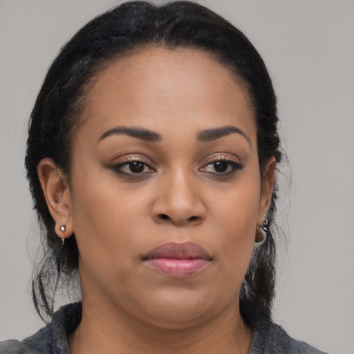 Joyful black young-adult female with long  brown hair and brown eyes