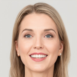 Joyful white young-adult female with long  brown hair and green eyes