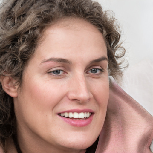 Joyful white young-adult female with long  brown hair and blue eyes