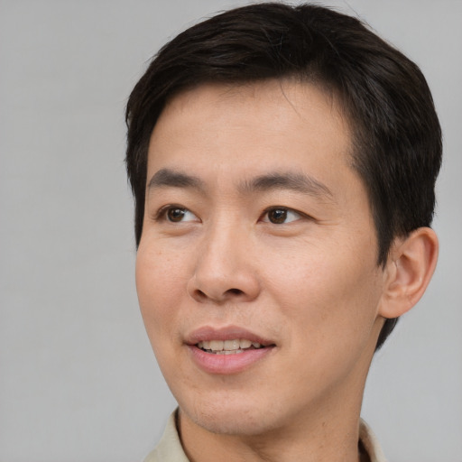 Joyful asian young-adult male with short  brown hair and brown eyes