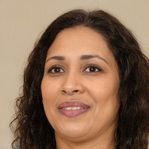 Joyful latino adult female with long  brown hair and brown eyes