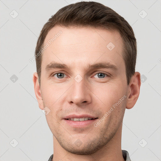 Joyful white young-adult male with short  brown hair and grey eyes