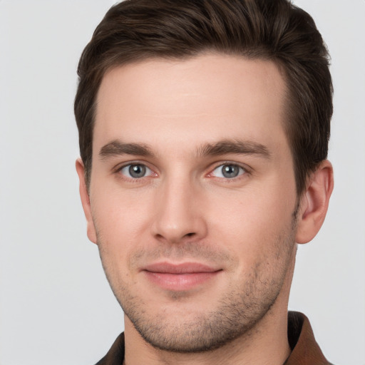 Joyful white young-adult male with short  brown hair and grey eyes