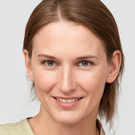 Joyful white young-adult female with medium  brown hair and grey eyes