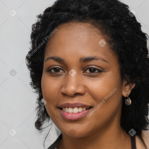 Joyful black young-adult female with long  black hair and brown eyes