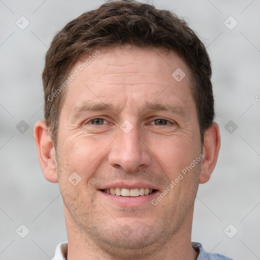 Joyful white adult male with short  brown hair and grey eyes