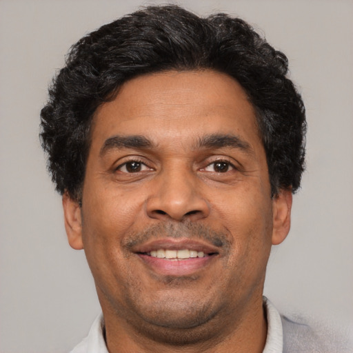 Joyful latino adult male with short  brown hair and brown eyes