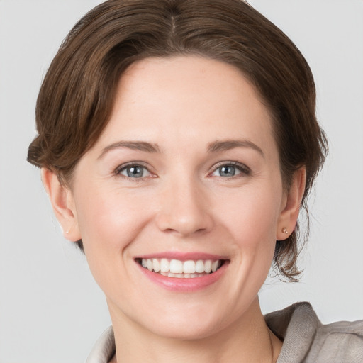 Joyful white young-adult female with short  brown hair and grey eyes