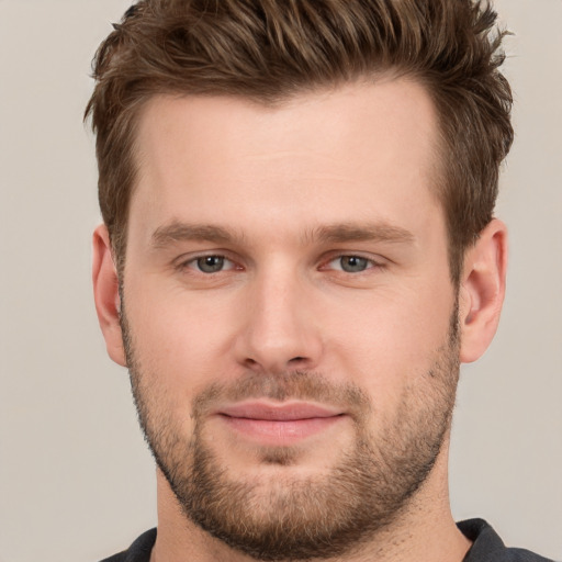 Joyful white young-adult male with short  brown hair and grey eyes