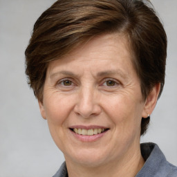 Joyful white middle-aged female with medium  brown hair and grey eyes