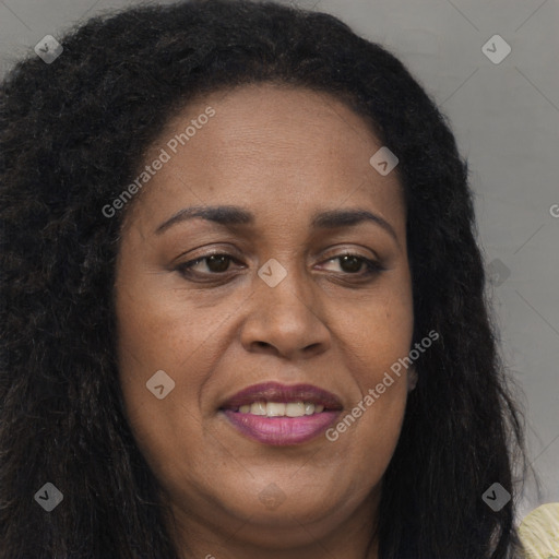 Joyful black adult female with long  brown hair and brown eyes