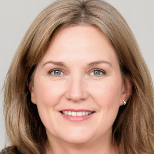 Joyful white adult female with long  brown hair and grey eyes